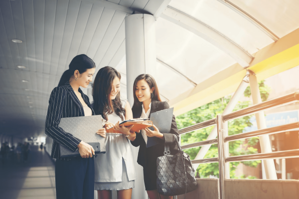 businesswomen-discussing-paperwork-together-against-railing-business-people-concept_1150-2377
